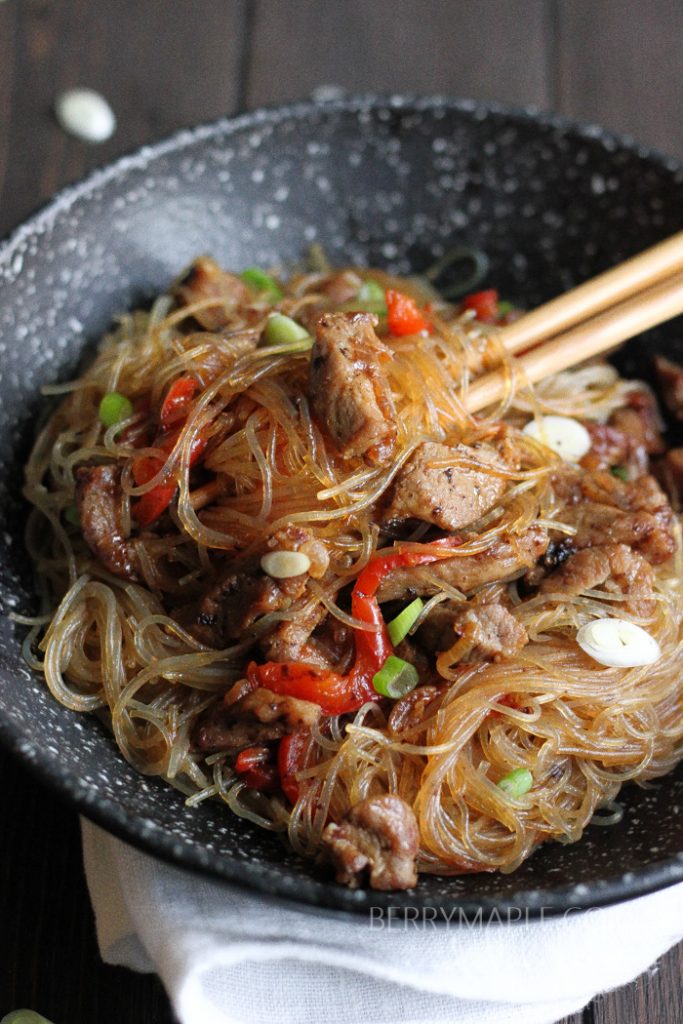 Clear noodles pork stir fry ini a black bowl