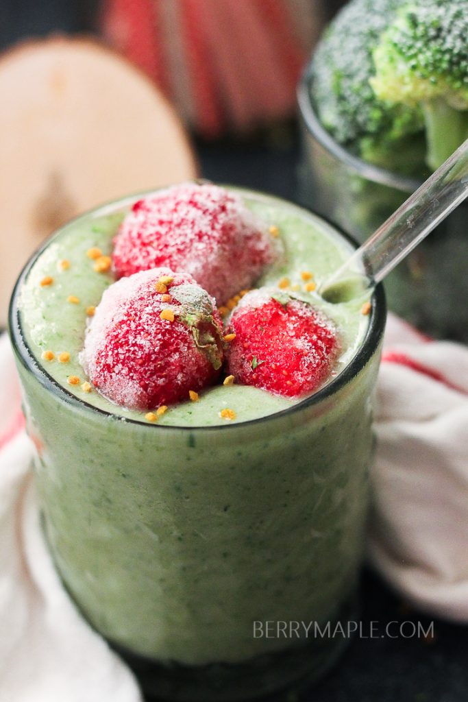green broccoli detox smoothie in the glass with strawberries on top