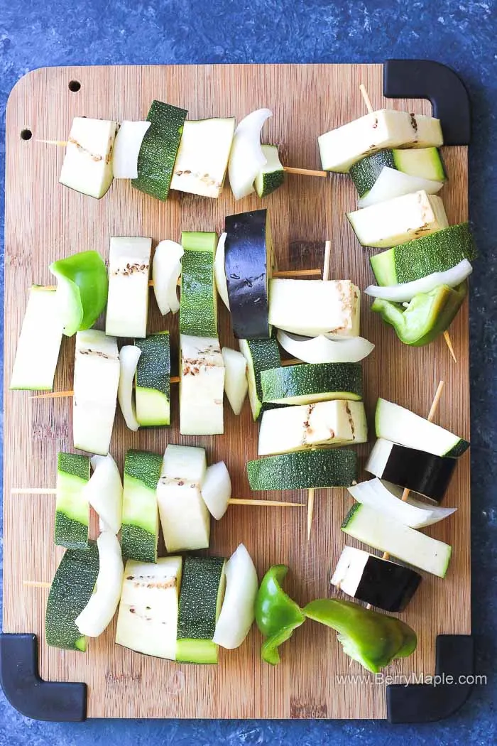 raw veggie skewers on a cutting board