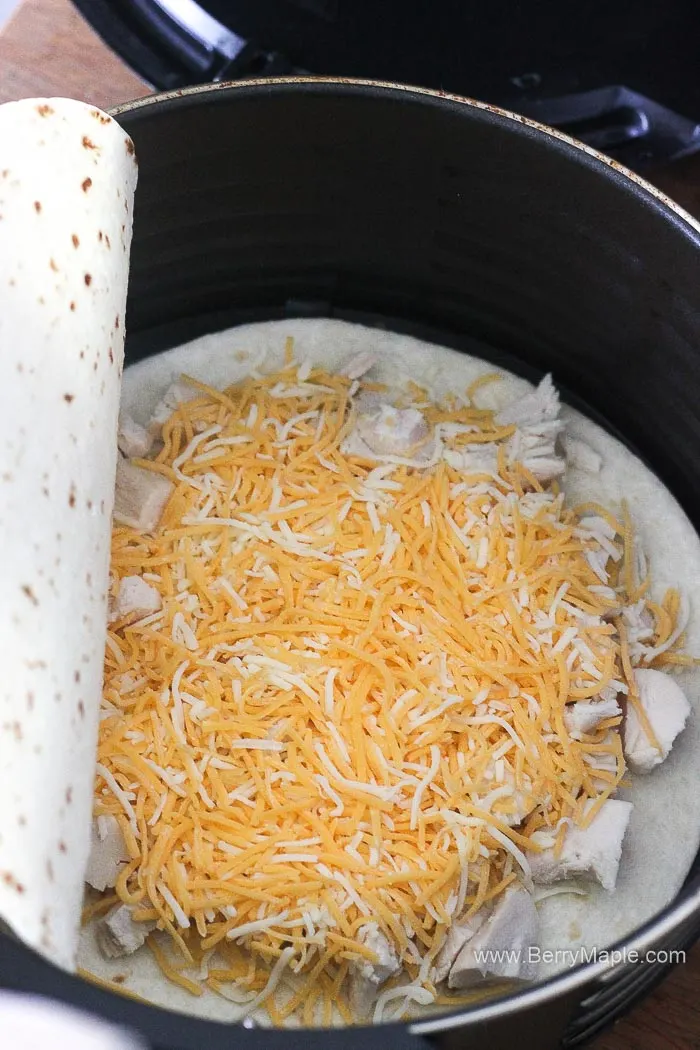 shredded cheese on top of tortilla