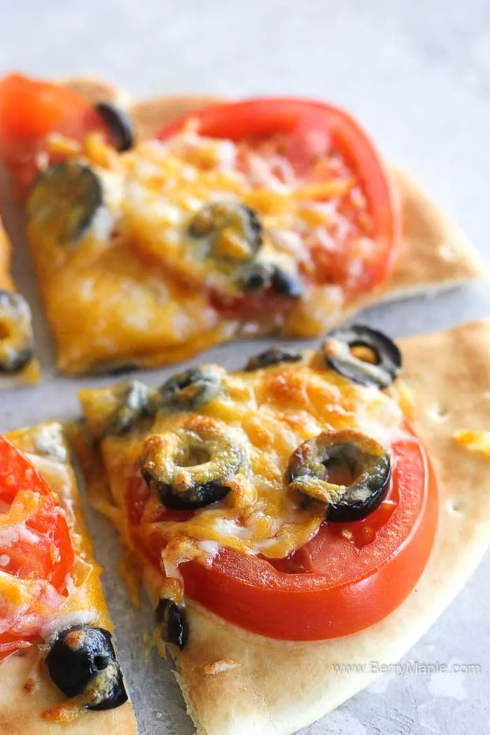 sliced pizza with tomatoes, olives, cheese