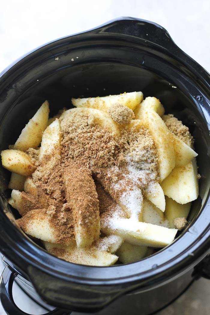 chopped apples in a slow cooker with sugar