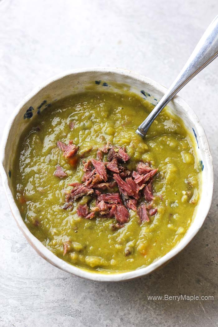 a bowl of split pea soup with smoked bacon pieces on top
