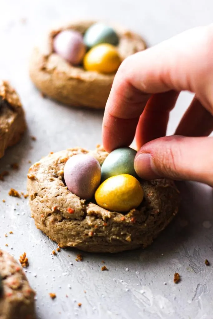 adding candies to easter nest cookies