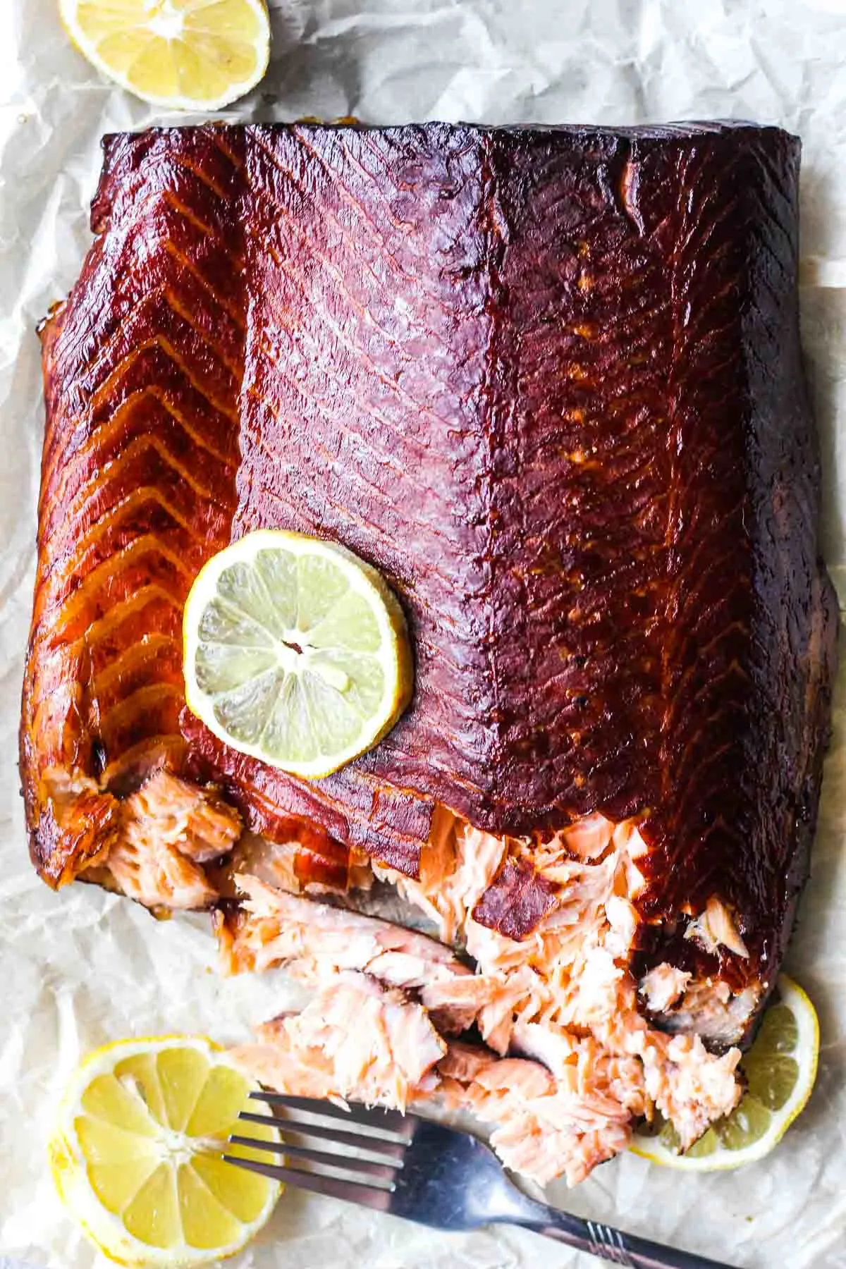 Top shot of smoked fish fillet flaked with a fork from the side