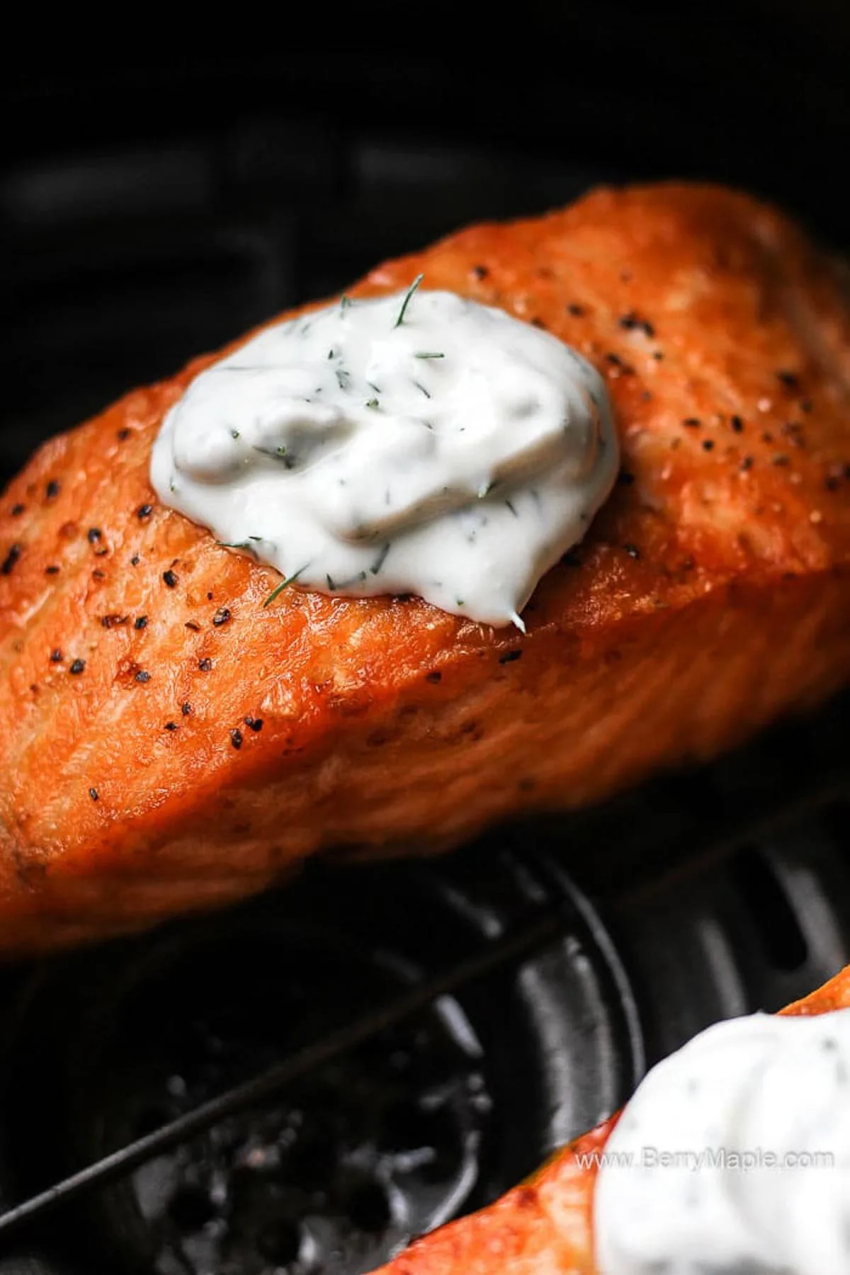 close shot of red fish with white sauce on top