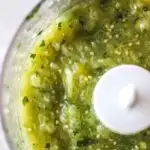 square image of green salsa inside the blender bowl