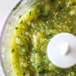 square image of green salsa inside the blender bowl