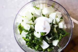 chopped white onion and cilantro in a blender