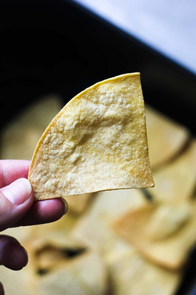 a yellow tortilla chip in the hand