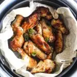 roasted wings in the pot with chopped green onions on top