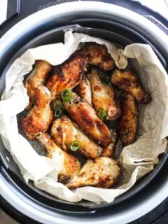 roasted wings in the pot with chopped green onions on top