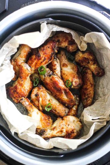 roasted wings in the pot with chopped green onions on top