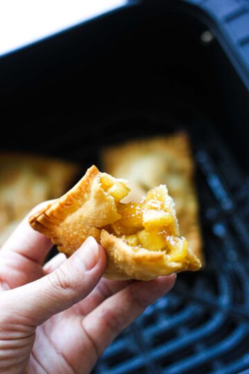 fried mini apple pie in hand
