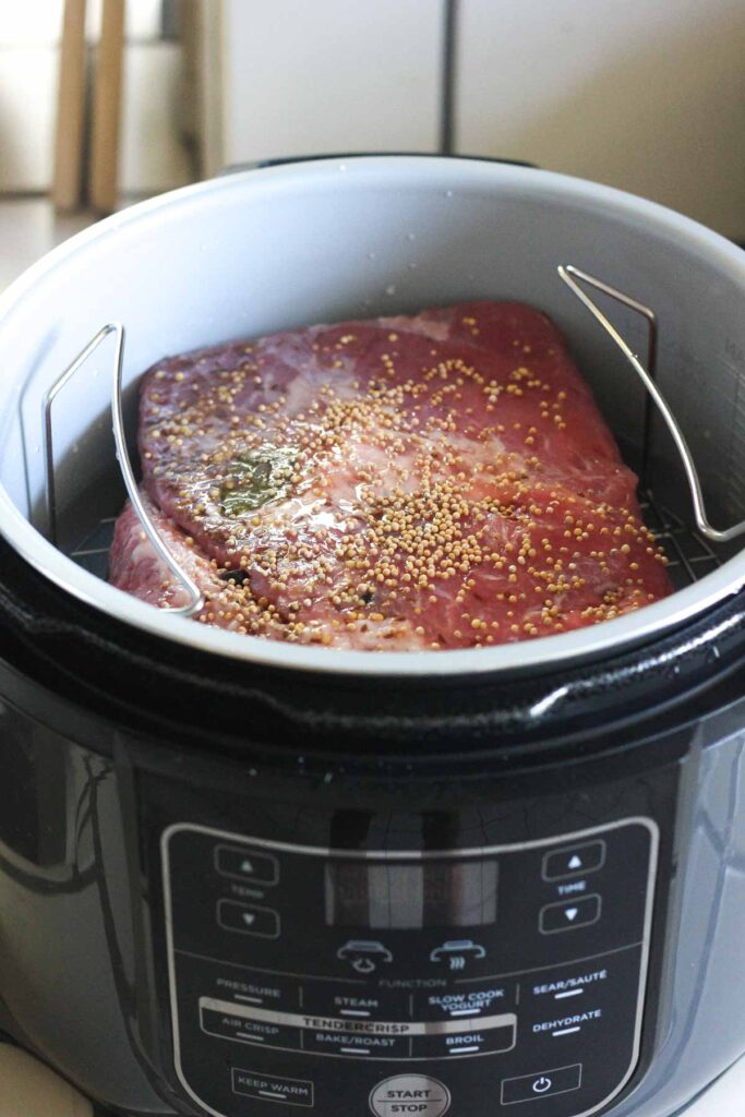 side view of raw flat cut corned beef brisket in ninja foodi