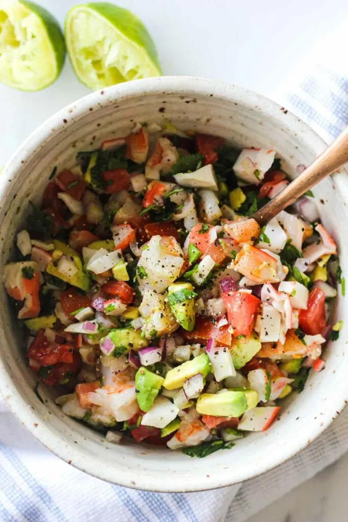 chopped avocado, onions, tomato, cilantro, shrimp and crab in a bowl