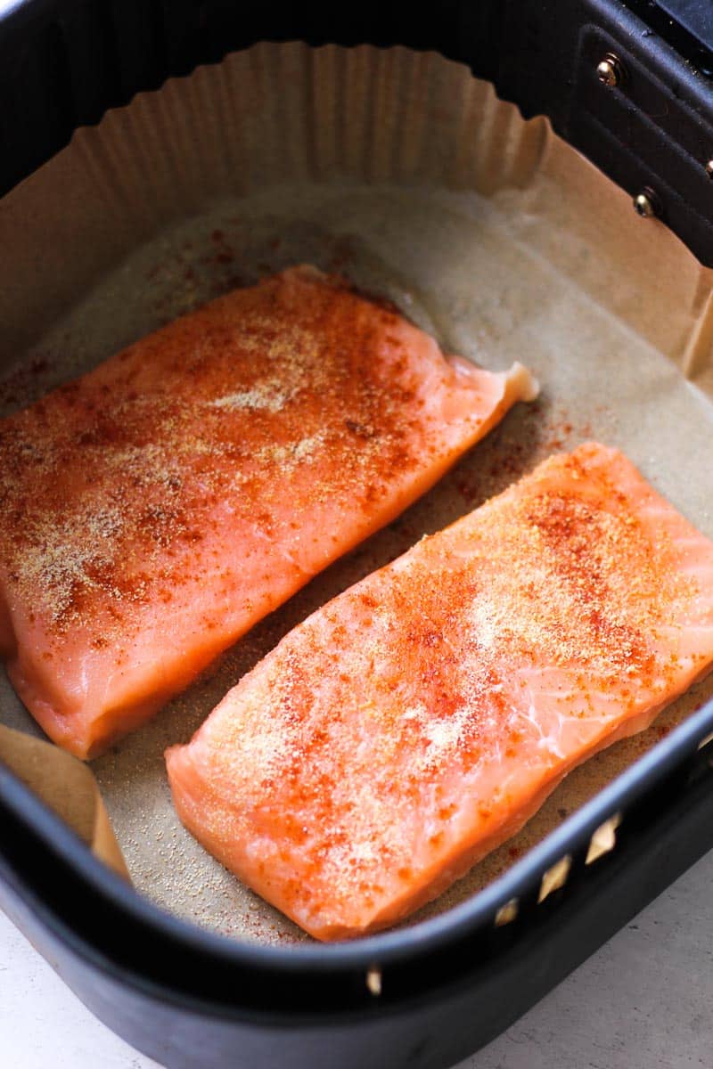 two seasoned salmon fillets in air fryer