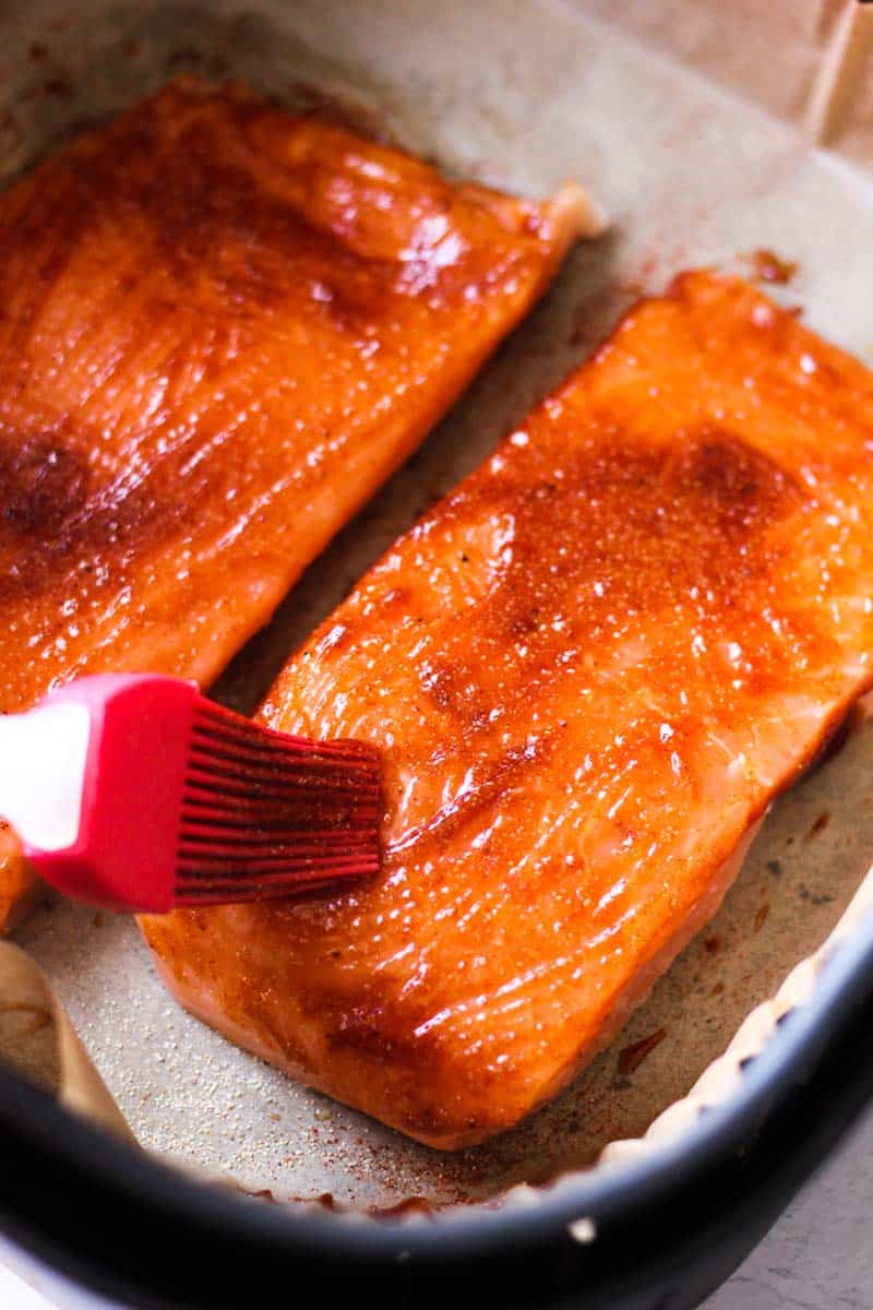 brushing bbq sauce on top of salmon fillets