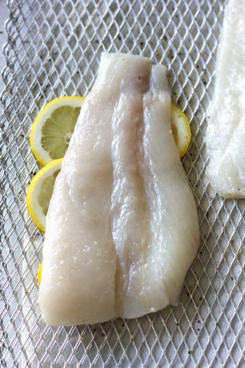 raw halibut fillet on top of lemon slices