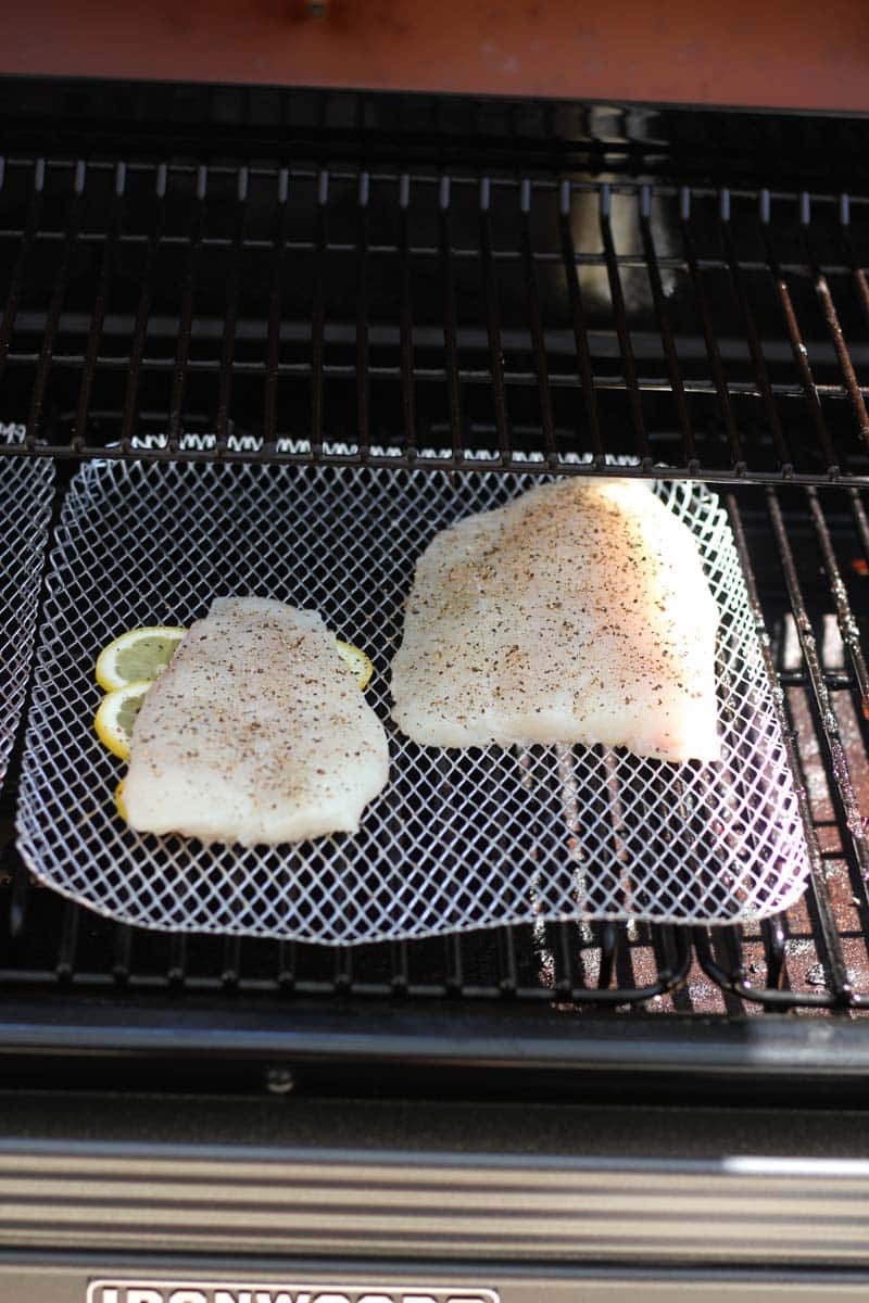 raw seasoned fish fillet in smoker