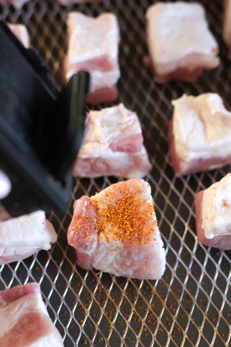 adding spice rub to pork before cooking