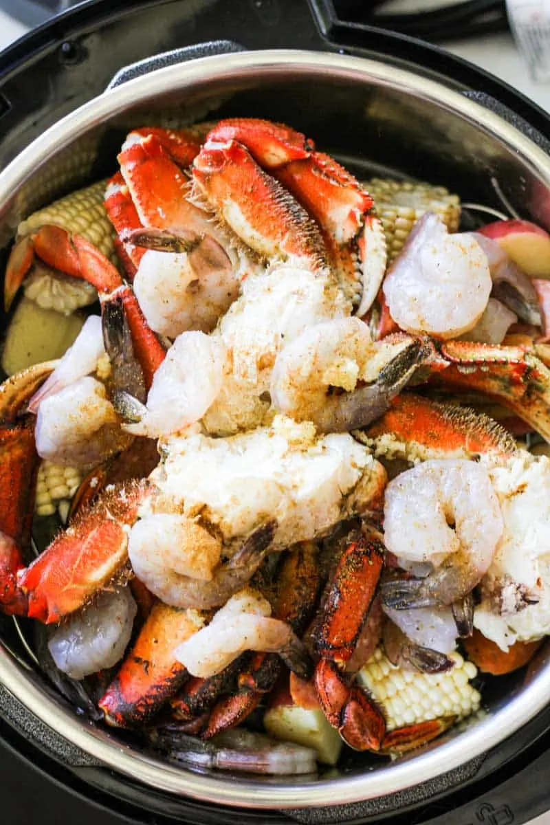 lots of seafood and vegetables in the pressure cooker pot